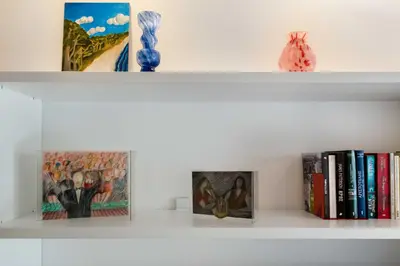a white shelf with books and paintings on it at Brand new apartment in Athens in Athens