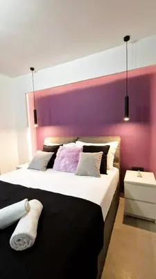 a bedroom with a large bed with a purple wall at Essél Noir - A hidden gem with a magnificent Acropolis view in Athens