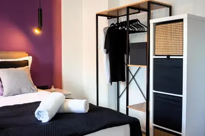 a bedroom with a bed and a closet at Essél Noir - A hidden gem with a magnificent Acropolis view in Athens