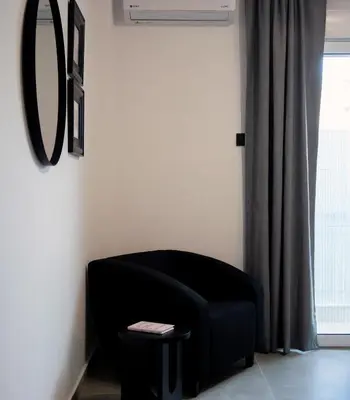 a black couch in a room with a mirror at Essél Noir - A hidden gem with a magnificent Acropolis view in Athens