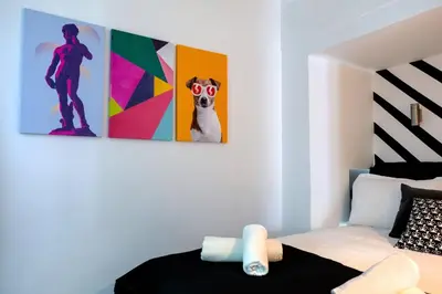 a bedroom with a bed and two paintings on the wall at Essél Noir - A hidden gem with a magnificent Acropolis view in Athens