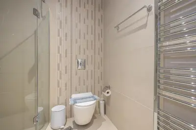 a bathroom with a toilet and a glass shower at Stylish Urban Suites in Athens