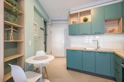 a kitchen with blue cabinets and a white table and chairs at Stylish Urban Suites in Athens
