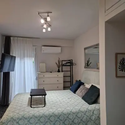 a bedroom with a bed and a dresser and a window at Chic apt near Acropolis - Avdi square in Athens