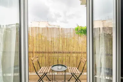 a table and two chairs on a balcony with a window at Chic apt near Acropolis - Avdi square in Athens