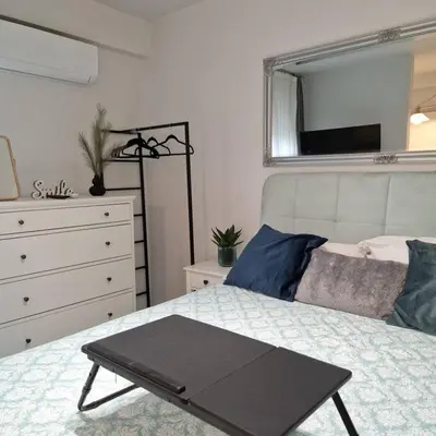 a bedroom with a bed with a dresser and a mirror at Chic apt near Acropolis - Avdi square in Athens