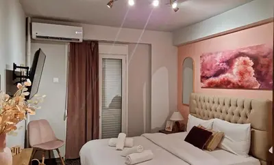 a bedroom with a bed and a painting on the wall at Stylish and central apt near Acropolis - Avdi square in Athens