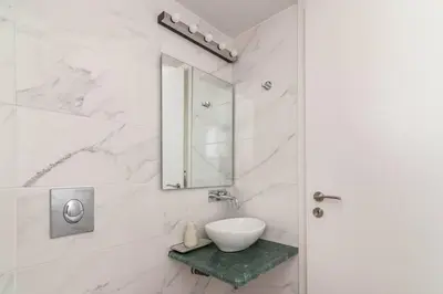 a white bathroom with a sink and a mirror at Stylish and central apt near Acropolis - Avdi square in Athens