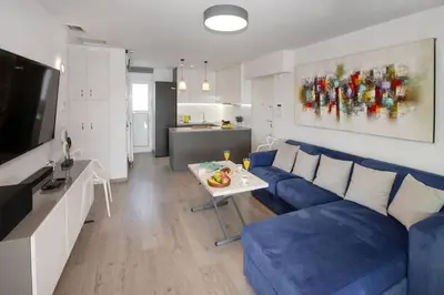 a living room with a blue couch and a table at Sea view penthouse in Vari in Vari