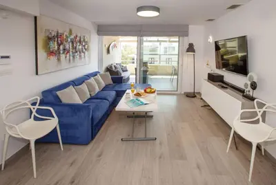 a living room with a blue couch and a table at Sea view penthouse in Vari in Vari