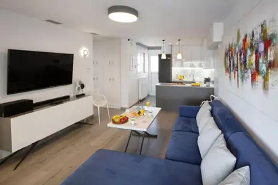 a living room with a blue couch and a table at Sea view penthouse in Vari in Vari