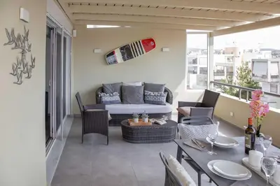 a living room with a couch and a table on a balcony at Sea view penthouse in Vari in Vari