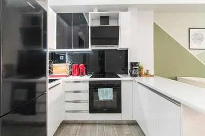 a kitchen with white cabinets and black appliances at Luxury Studio in Athens City Center in Athens
