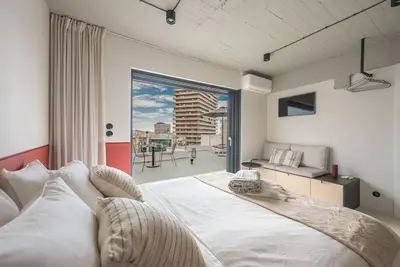 a bedroom with a large white bed and a large window at City-View Penthouse at Panormou in Athens
