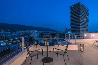 a patio with chairs and a table on a balcony at City-View Penthouse at Panormou in Athens