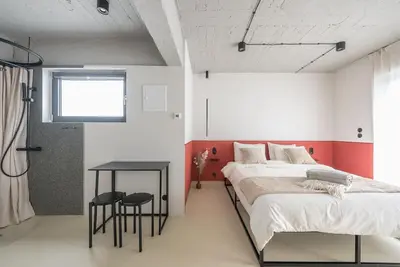a bedroom with two beds and a table and a window at City-View Penthouse at Panormou in Athens