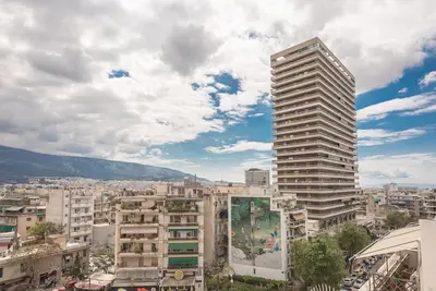 a tall building in a city with buildings at City-View Penthouse at Panormou in Athens