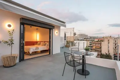 a balcony with a bedroom and a bed and a table at City-View Penthouse at Panormou in Athens