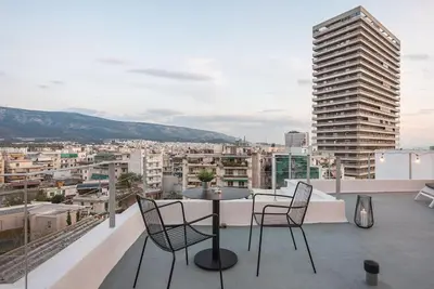 a balcony with a table and chairs and a city at City-View Penthouse at Panormou in Athens