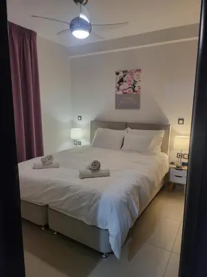 a bedroom with a large bed with two towels on it at Bovis Apartments #1 in Markopoulo