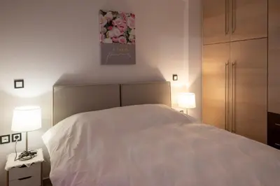 a bedroom with a white bed and two lamps at Bovis Apartments #1 in Markopoulo