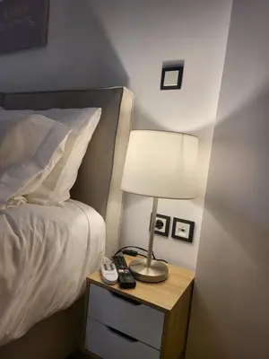 a lamp on a night stand next to a bed at Bovis Apartments #1 in Markopoulo