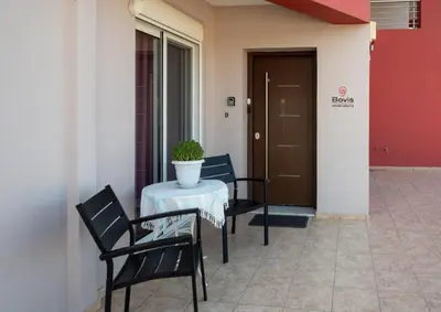 a patio with a table and chairs and a door at Bovis Apartments #1 in Markopoulo