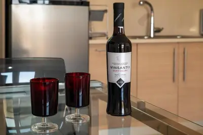a bottle of wine sitting on a table with two glasses at Bovis Apartments #1 in Markopoulo