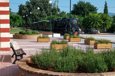 a train is parked in a park with a bench at Bovis Apartments #1 in Markopoulo