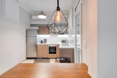 a kitchen with a table and chairs in a room at Modern 2-bedroom apt, 200m from the Acropolis in Athens