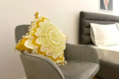 a yellow pillow on a chair next to a bed at Pame Rentals - Ideal for 2 in Pagrati in Athens