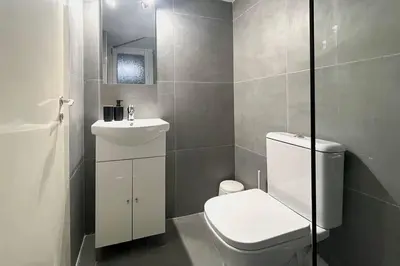 a bathroom with a white toilet and a sink at Pame Rentals - Ideal for 2 in Pagrati in Athens