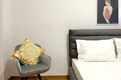 a bedroom with a bed and a chair with a pillow at Pame Rentals - Ideal for 2 in Pagrati in Athens