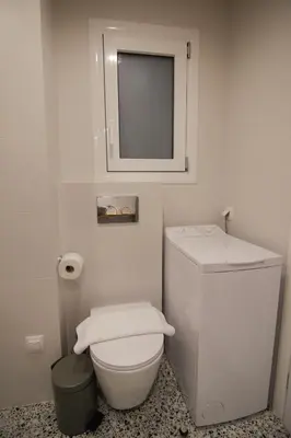 a white bathroom with a toilet and a mirror at Patio Apartment near metro & Acropolis in Athens