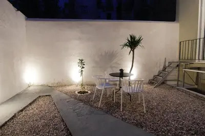a patio with a table and chairs and a palm tree at Patio Apartment near metro & Acropolis in Athens