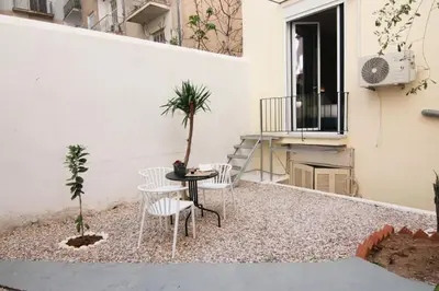 a small courtyard with a table and chairs on a balcony at Patio Apartment near metro & Acropolis in Athens