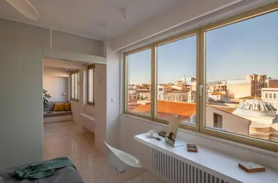 a room with a desk and large windows at ATHENS CENTRAL APARTMENT in Athens