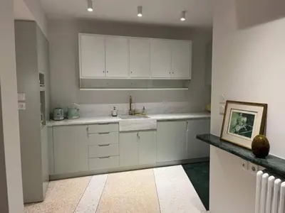 a kitchen with white cabinets and a picture on the counter at ATHENS CENTRAL APARTMENT in Athens