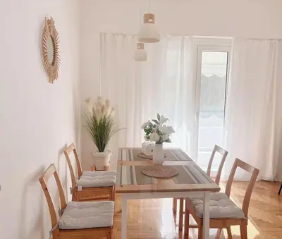 a dining room with a wooden table and chairs at Sunny two-bedroom apartment next to Panathenaic Stadium in Athens