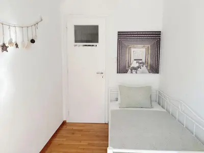 a white room with a couch and a door at Sunny two-bedroom apartment next to Panathenaic Stadium in Athens