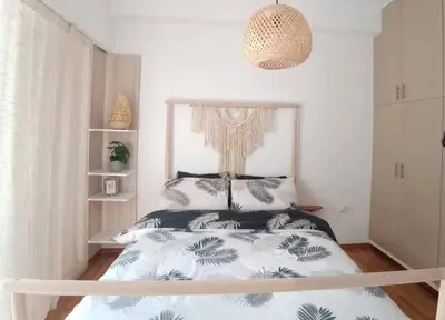 a bedroom with a bed with a black and white comforter at Sunny two-bedroom apartment next to Panathenaic Stadium in Athens