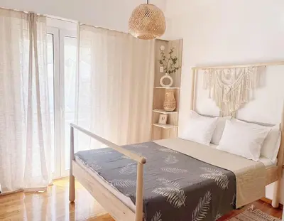 a bedroom with a bed with a large window at Sunny two-bedroom apartment next to Panathenaic Stadium in Athens