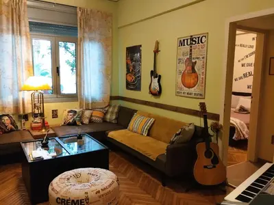 a living room with a couch and guitars on the wall at Still got the blues in Athens
