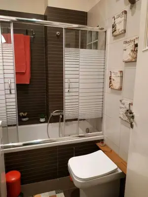 a bathroom with a toilet and a shower with a window at Still got the blues in Athens
