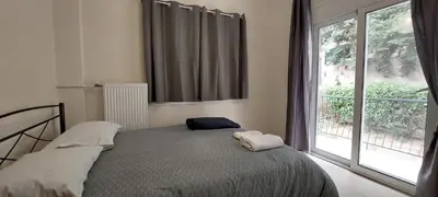 a bedroom with a bed and a large window at Cozy apartment in Nea Smyrni in Athens