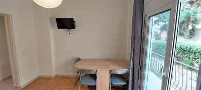 a small table with two chairs and a tv on a wall at Cozy apartment in Nea Smyrni in Athens