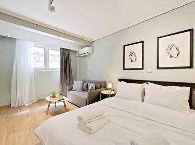 a bedroom with a large white bed and a couch at 5min Metro, Sotiria, Iatriko, Semi-Basement in Athens