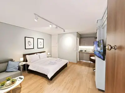 a bedroom with a bed and a couch and a kitchen at 5min Metro, Sotiria, Iatriko, Semi-Basement in Athens