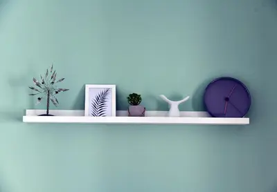a white shelf with plants and a clock on a wall at Dunant Studio in Athens