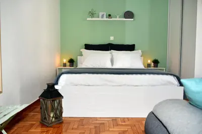 a bedroom with a large white bed and a couch at Dunant Studio in Athens